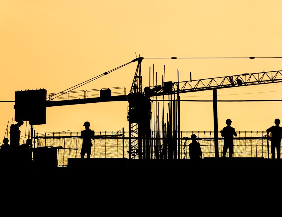 silhouette of people standing on tower crane during night time